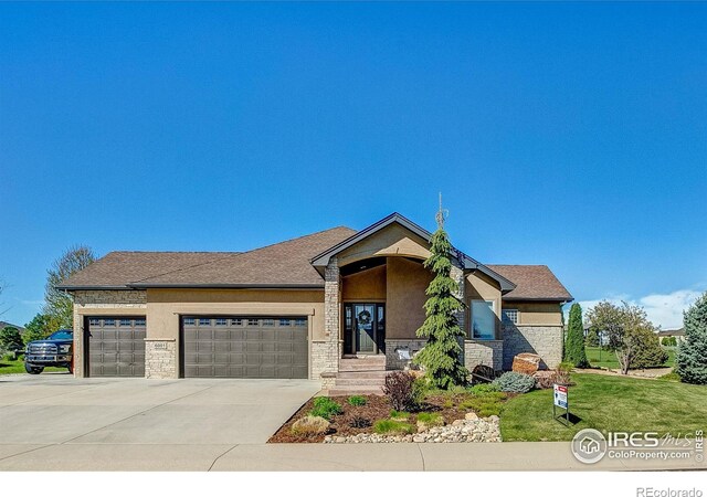 view of front of property featuring a garage and a front lawn