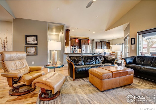 living room with vaulted ceiling, light hardwood / wood-style flooring, and ceiling fan