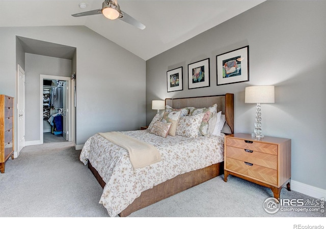 bedroom with ceiling fan, a closet, vaulted ceiling, a spacious closet, and carpet floors