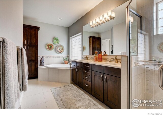 bathroom featuring tile patterned floors, independent shower and bath, an inviting chandelier, and vanity