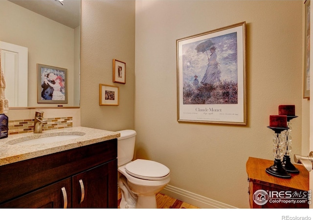 bathroom featuring vanity, toilet, hardwood / wood-style floors, and decorative backsplash