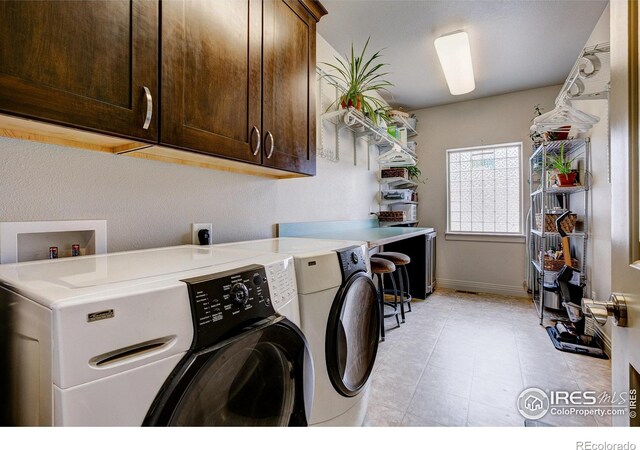 washroom with separate washer and dryer and cabinets