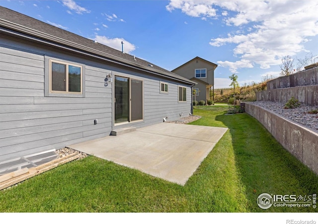 back of house with a yard and a patio