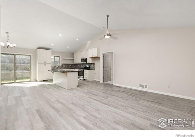 kitchen featuring a kitchen island, appliances with stainless steel finishes, backsplash, and white cabinetry