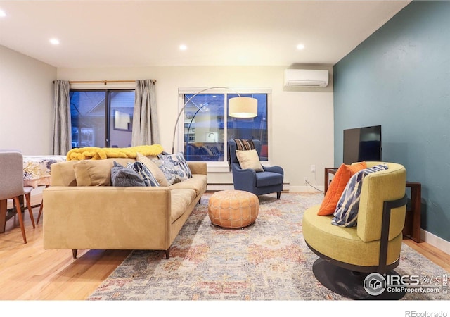 living area featuring baseboard heating, a wall mounted air conditioner, baseboards, and wood finished floors