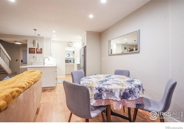 dining space featuring light hardwood / wood-style flooring and sink