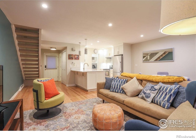 living room with light hardwood / wood-style floors and sink