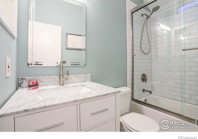 full bathroom with vanity, toilet, and bath / shower combo with glass door