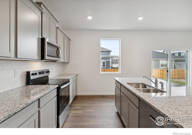 kitchen featuring sink, light wood-type flooring, stainless steel appliances, and a wealth of natural light