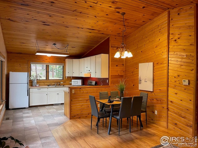 tiled dining area featuring wood ceiling, a chandelier, wood walls, and sink