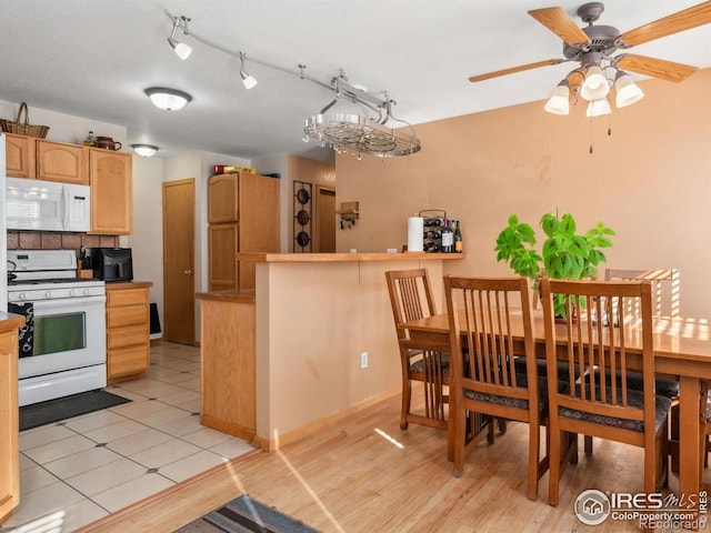 kitchen featuring light brown cabinetry, white appliances, and light hardwood / wood-style floors