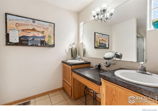 bathroom featuring a chandelier, vanity, tile patterned floors, and an enclosed shower