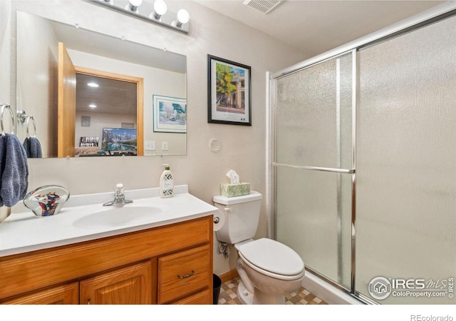 bathroom featuring tile patterned flooring, vanity, toilet, and walk in shower