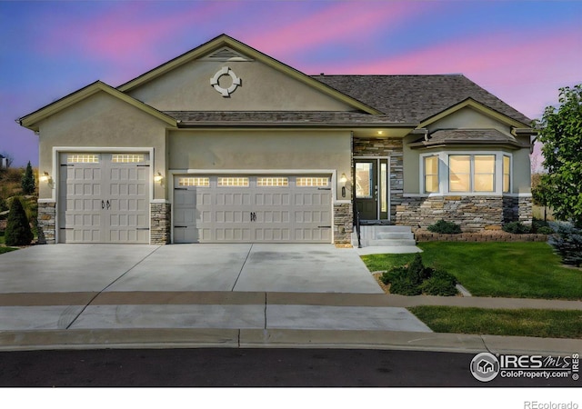 view of front of property featuring a yard and a garage