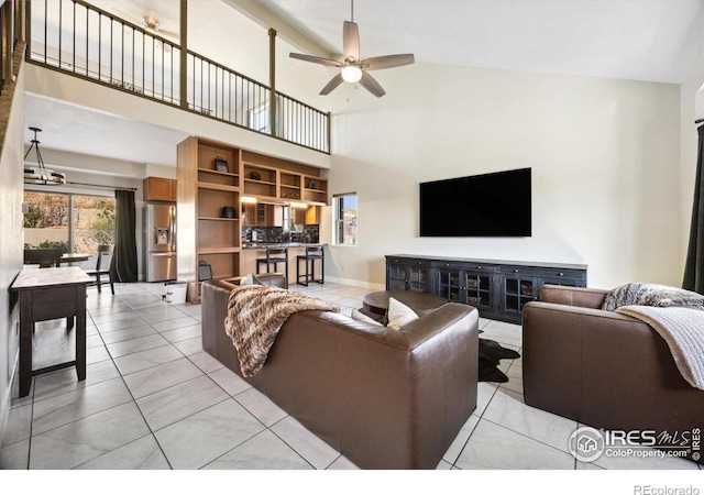 tiled living room featuring ceiling fan and high vaulted ceiling