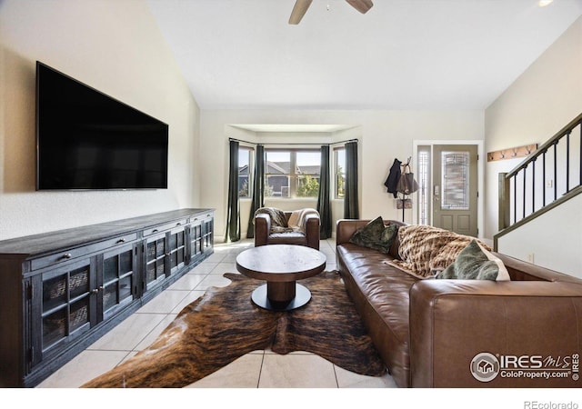 tiled living room with lofted ceiling and ceiling fan