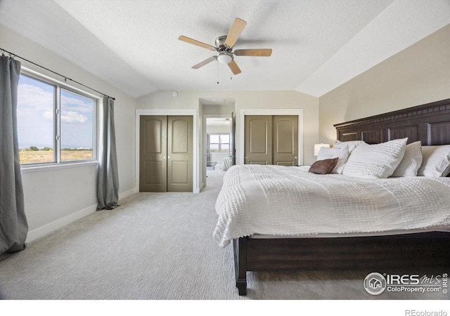 bedroom with vaulted ceiling, multiple windows, ceiling fan, and carpet