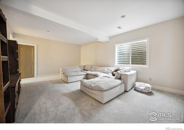 carpeted living room featuring beamed ceiling