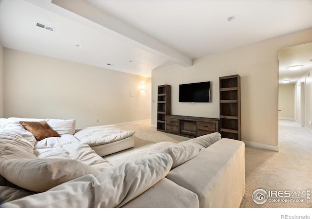 carpeted living room featuring beam ceiling