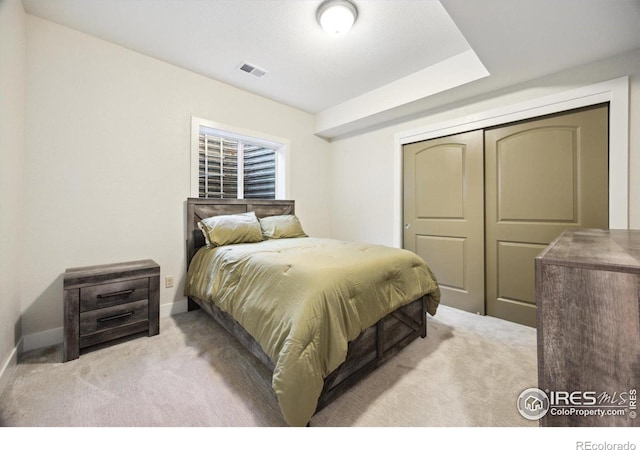 bedroom featuring light carpet and a closet