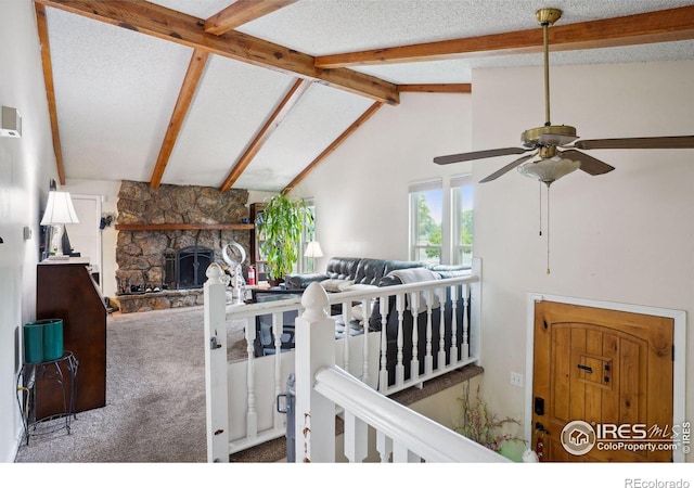 interior space featuring a fireplace, ceiling fan, lofted ceiling with beams, carpet flooring, and a nursery area