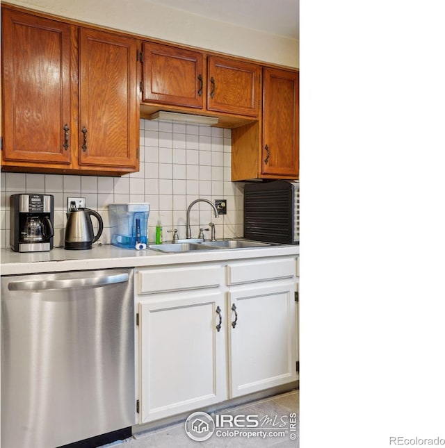 kitchen featuring dishwasher, sink, and backsplash