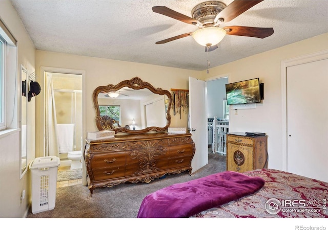 carpeted bedroom with ceiling fan, connected bathroom, and a textured ceiling