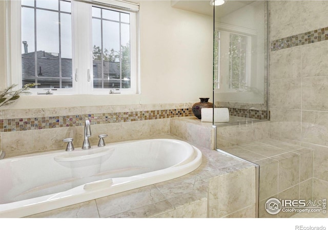 bathroom featuring a relaxing tiled tub