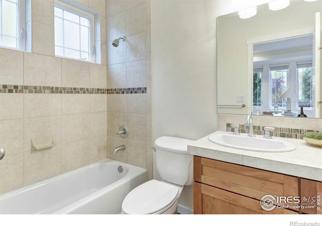 full bathroom with vanity, toilet, plenty of natural light, and tiled shower / bath