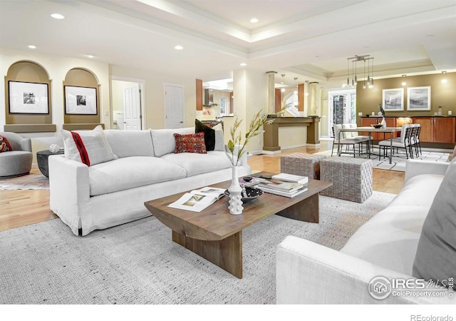 living room with light hardwood / wood-style flooring and a raised ceiling