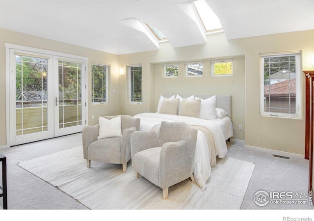 bedroom featuring french doors, access to outside, a skylight, and light colored carpet