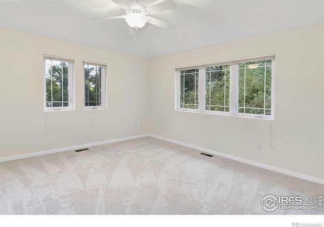 spare room featuring light carpet and ceiling fan