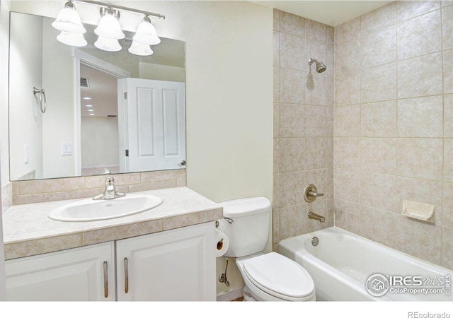 full bathroom featuring toilet, tiled shower / bath combo, and vanity