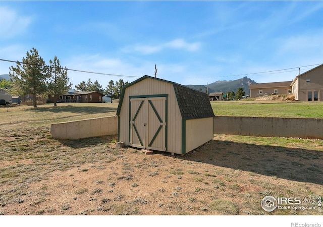 view of outdoor structure featuring a mountain view and a lawn