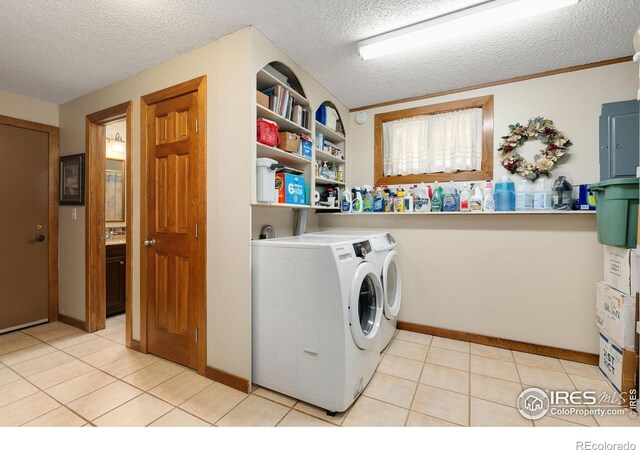 laundry area featuring a textured ceiling, light tile patterned floors, and independent washer and dryer