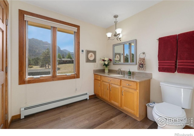 bathroom with baseboard heating, hardwood / wood-style floors, vanity, a notable chandelier, and a mountain view