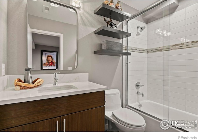 full bathroom featuring vanity, toilet, and bath / shower combo with glass door