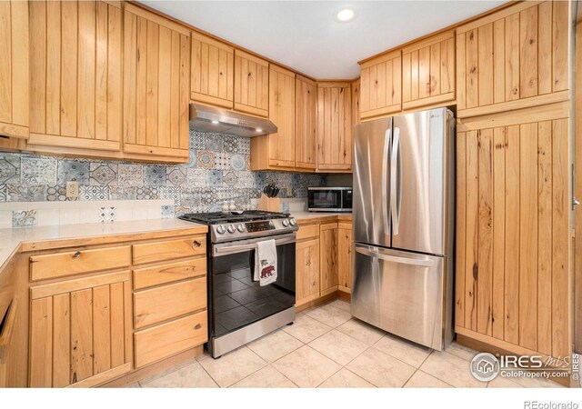 kitchen with decorative backsplash, appliances with stainless steel finishes, and light tile patterned floors