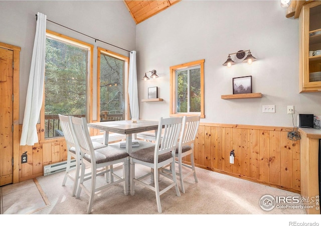 dining area featuring light carpet, a baseboard radiator, wooden ceiling, lofted ceiling, and wooden walls