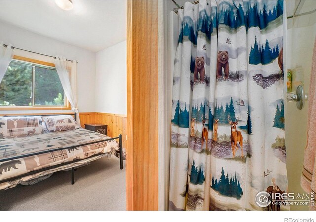 carpeted bedroom with wooden walls