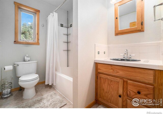 full bathroom with backsplash, tile patterned floors, toilet, shower / bath combo with shower curtain, and vanity