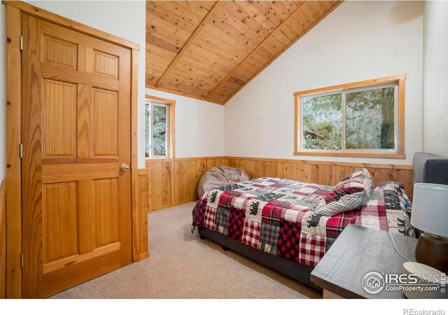 carpeted bedroom featuring vaulted ceiling, wooden ceiling, and wood walls