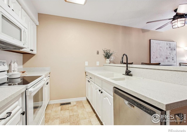 kitchen with white appliances, kitchen peninsula, sink, ceiling fan, and white cabinets