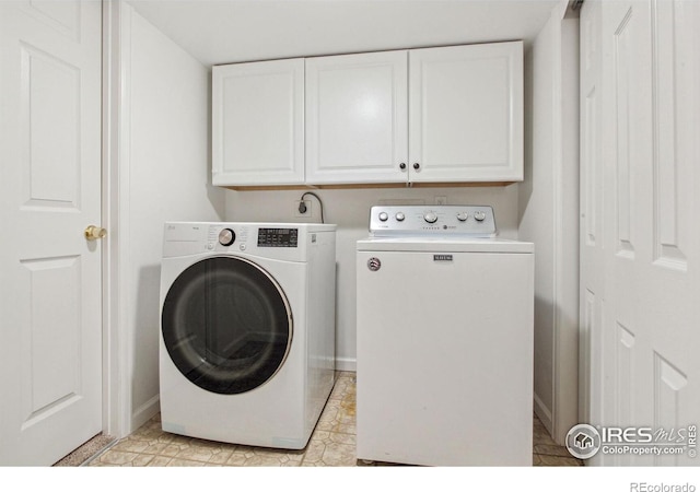 washroom featuring cabinets and independent washer and dryer