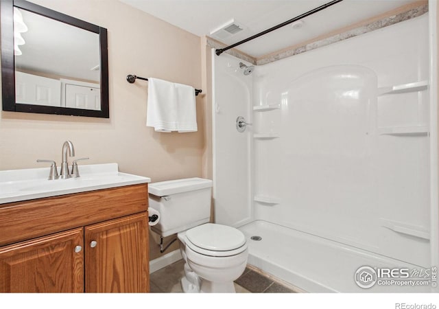 bathroom featuring tile patterned flooring, walk in shower, toilet, and vanity