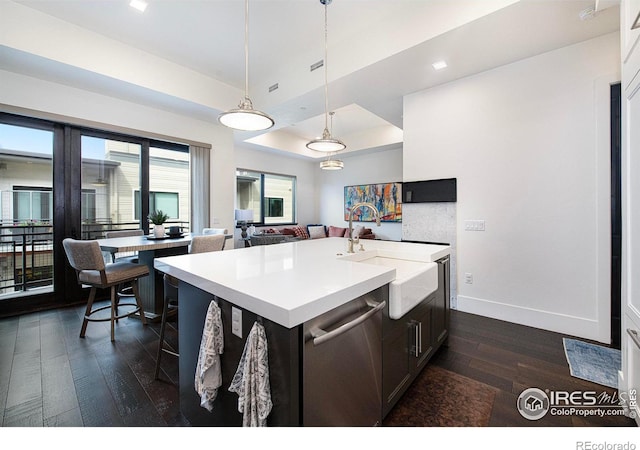 kitchen with a kitchen island with sink, dark hardwood / wood-style flooring, hanging light fixtures, and sink