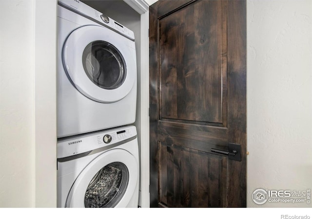 clothes washing area with stacked washer and dryer