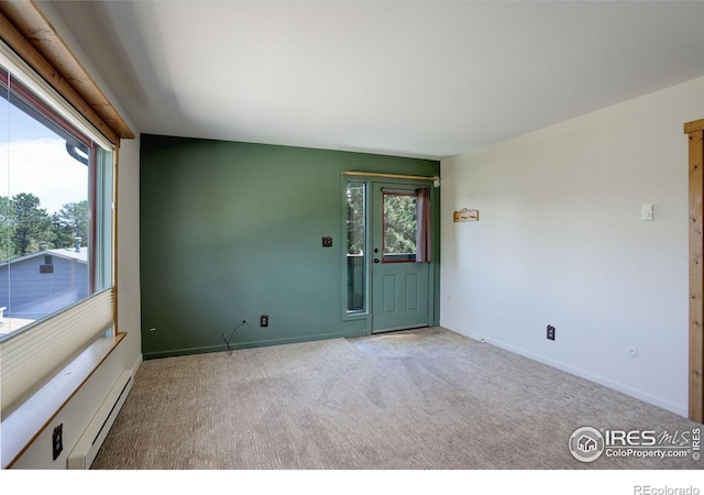 carpeted spare room featuring a healthy amount of sunlight and a baseboard radiator