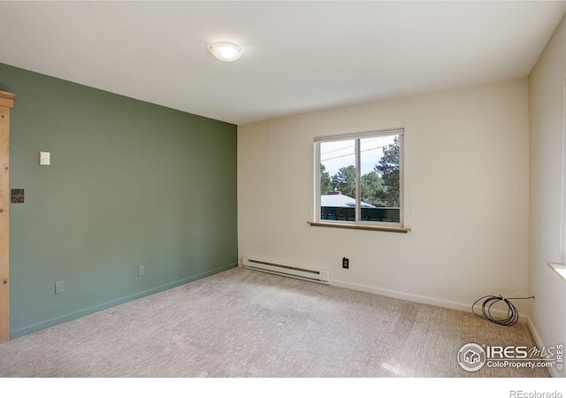 spare room featuring a baseboard radiator and light colored carpet