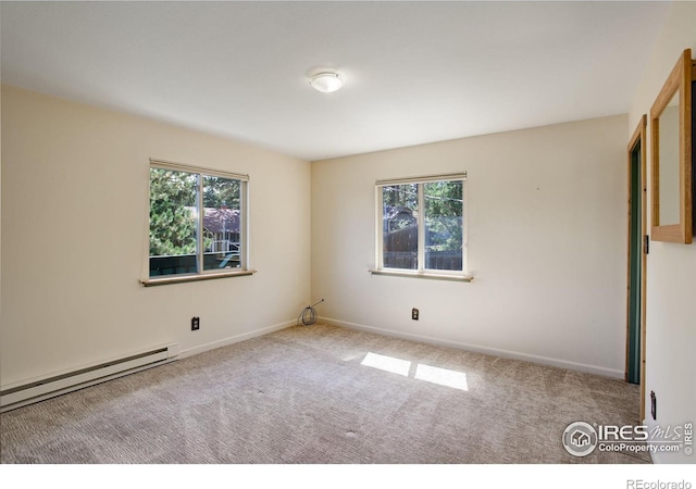 carpeted spare room featuring a baseboard heating unit